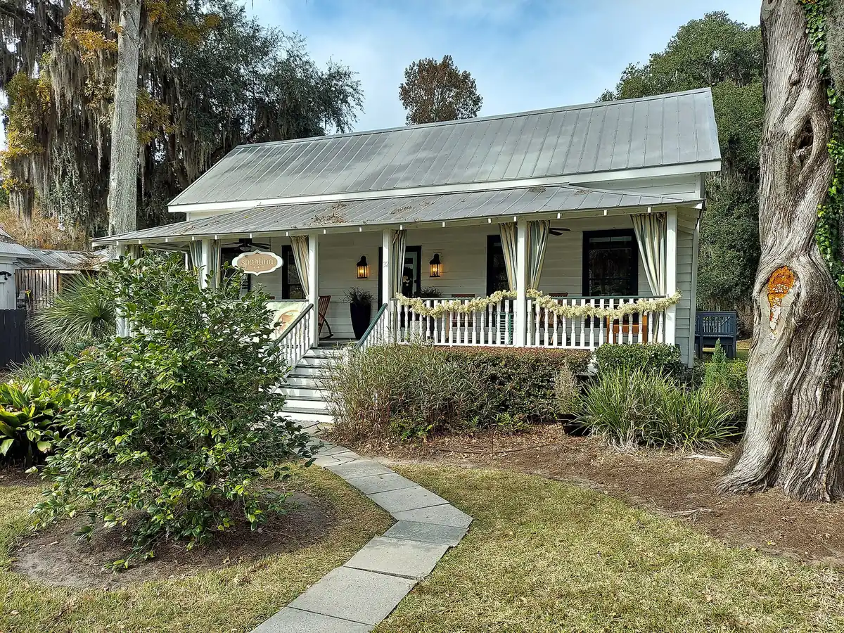 A cottage with a metal roof and a wide front porch in Bluffton.
