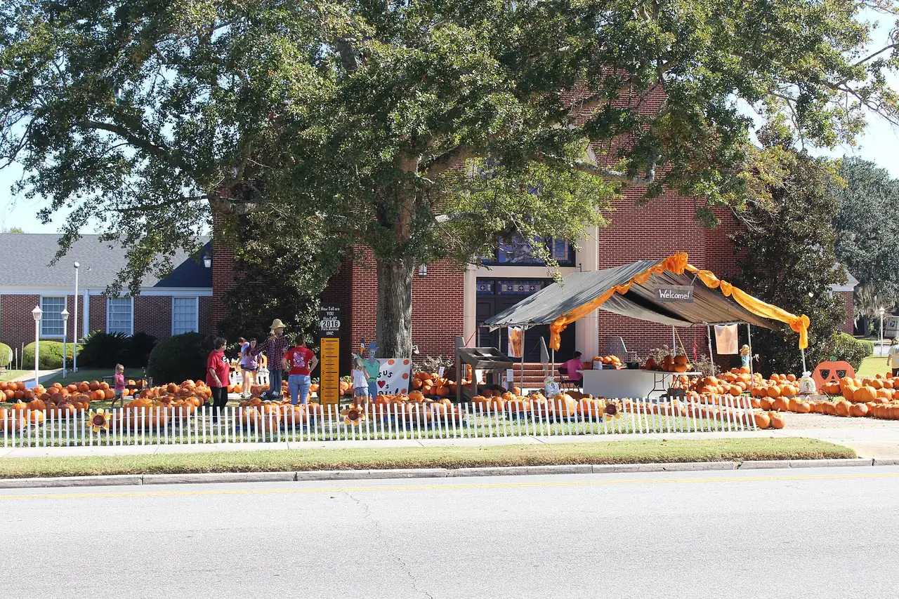 Families browse rows of pumpkins at a church pumpkin patch at Park Avenue United Methodist Church in Valdosta, Ga.