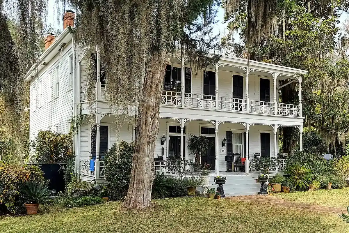 A two-story white house with double porches under live oaks and Spanish moss in Bluffton.