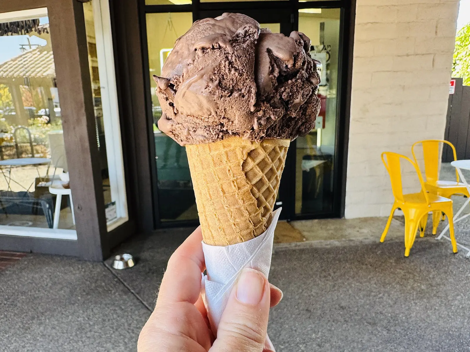 A scoop of dark chocolate chip ice cream on a sugar cone at an ice cream shop in Sonoma, California. The photo was not taken in Bluffton.