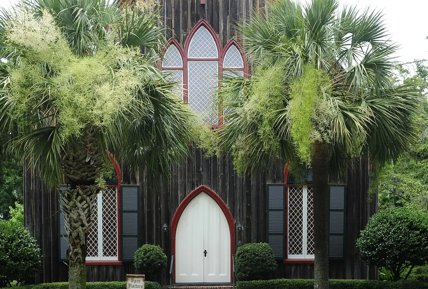 Palmetto trees frame the board-and-batten front of the Church of the Cross in Old Town Bluffton, whose members sell shrimp salad sandwiches at Mayfest.