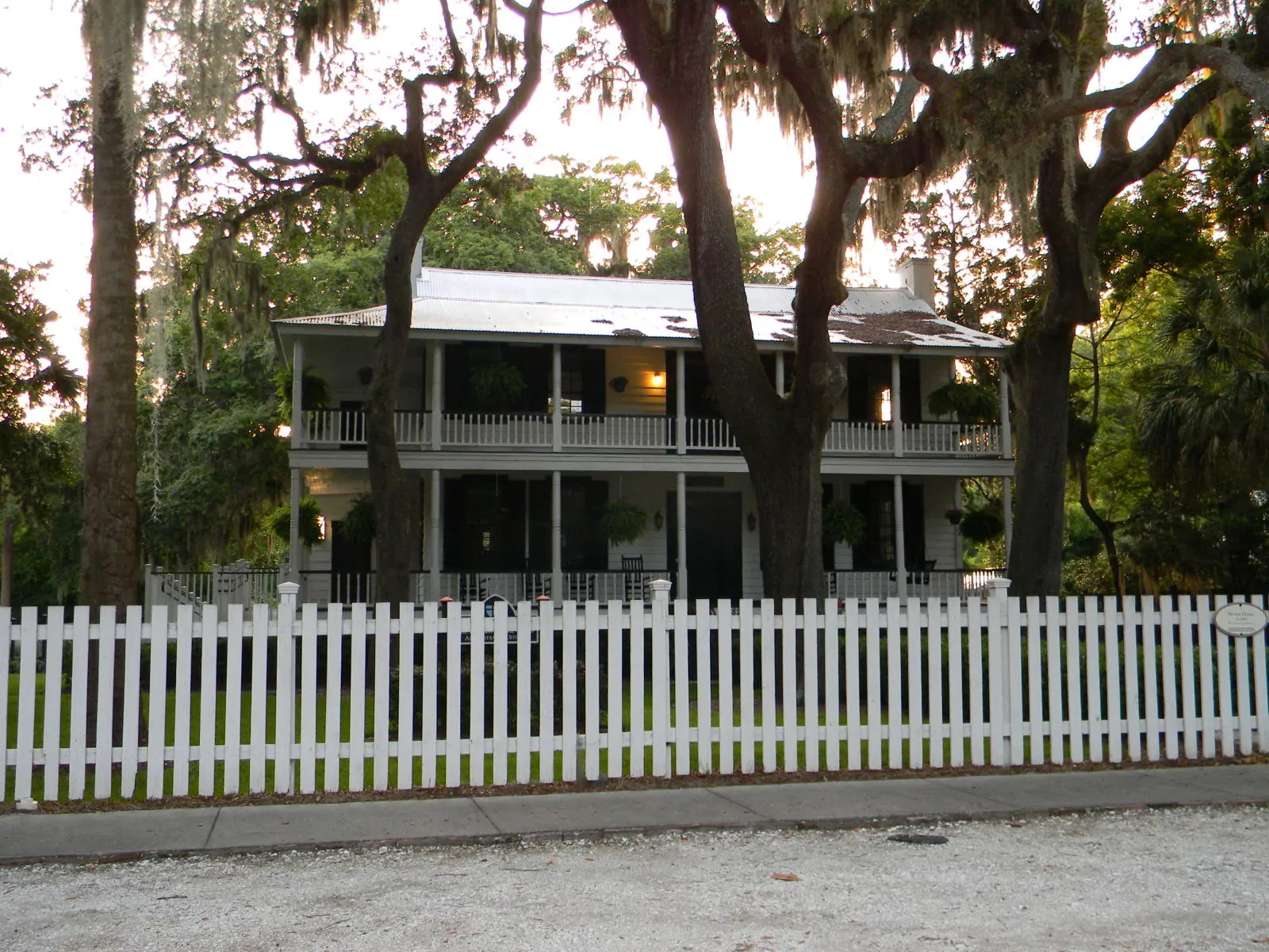 Seven Oaks, a two-story house with double porches behind a white picket fence in the Bluffton Historic District.
