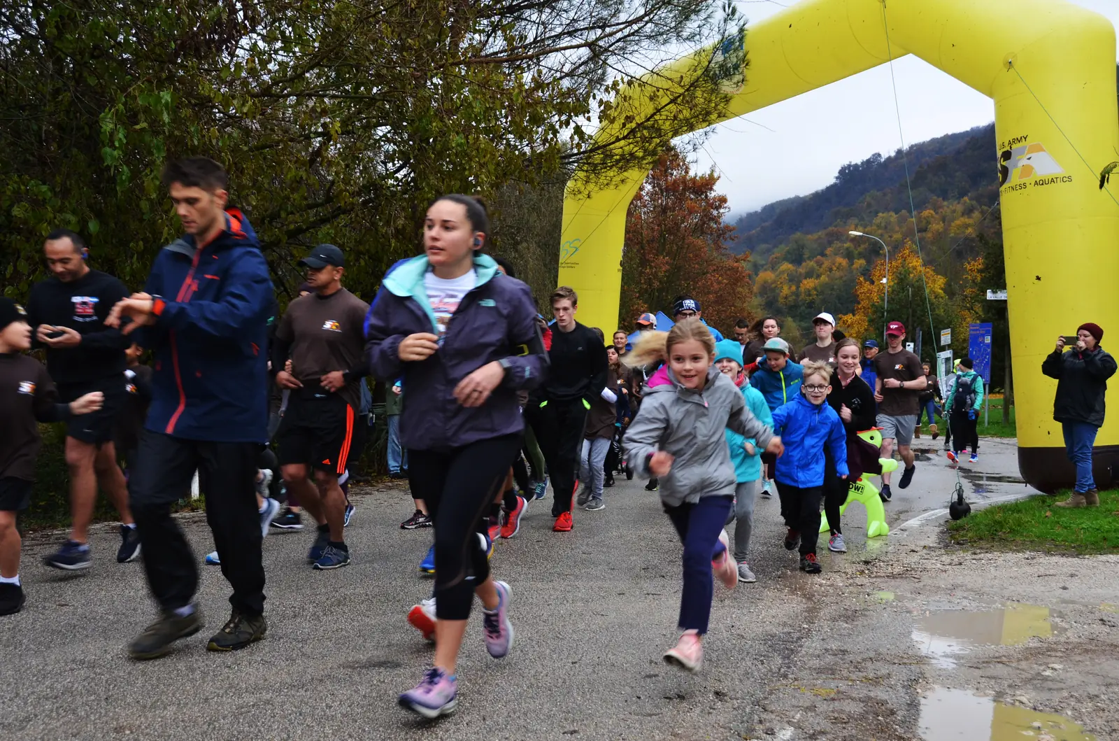 Runners set off from the start arch of a Thanksgiving turkey trot fun run on a lakeside trail near Vicenza, Italy.