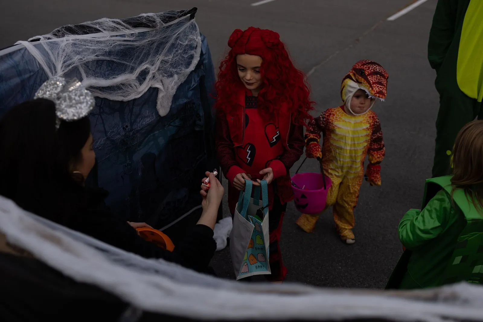 Children in costume collect candy from a decorated car trunk at a trunk-or-treat at Fort Drum, New York.