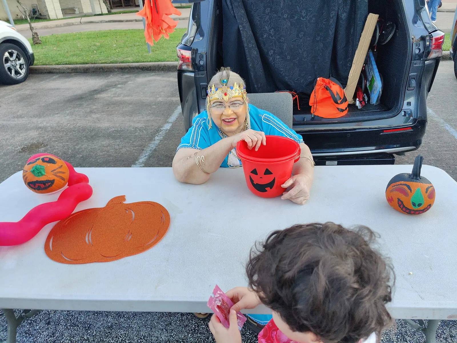 A volunteer in costume hands out candy from the back of a minivan at a trunk-or-treat at Westbury United Methodist Church in Houston.