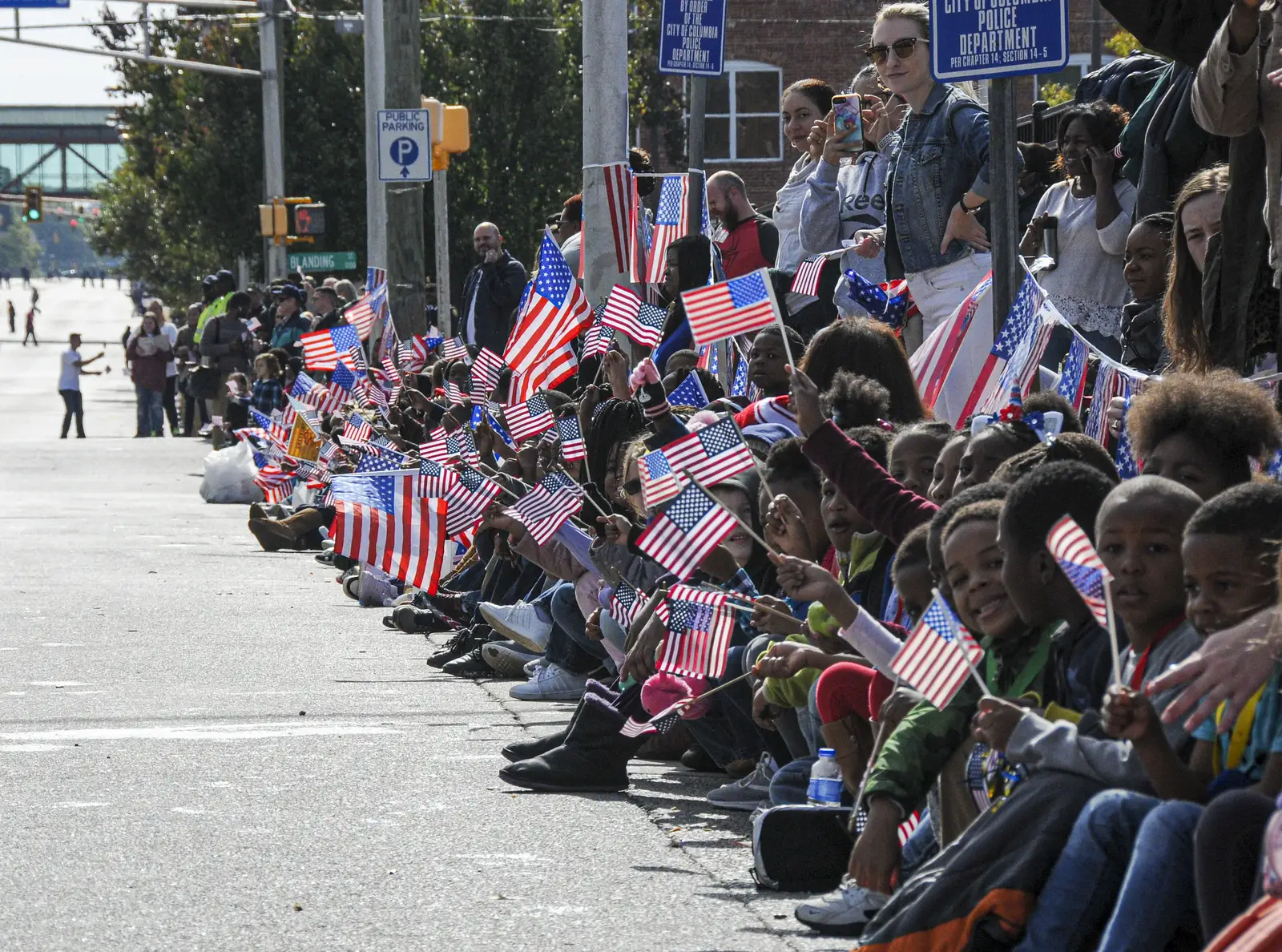 Children wave American flags along the curb at the annual Veterans Day parade in Columbia, S.C.
